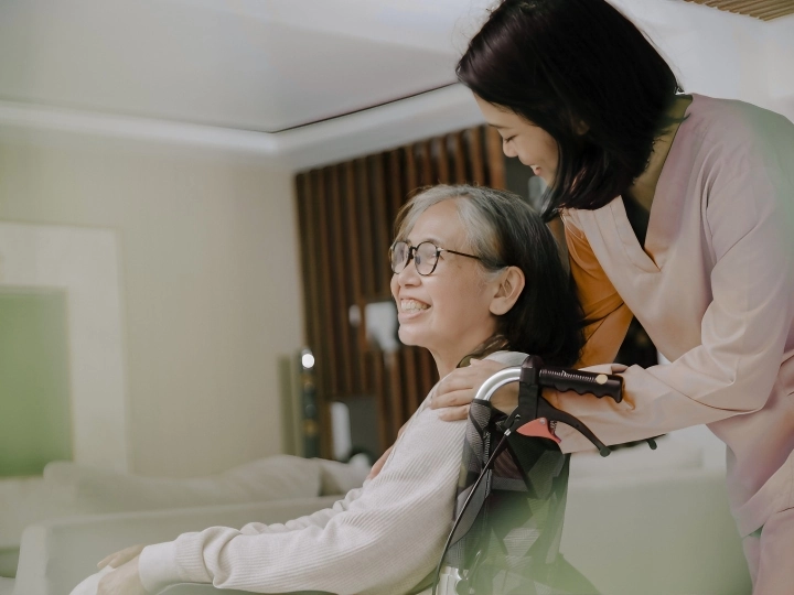 Chăm sóc người bệnh tại nhà TP.HCM — người chăm đẩy xe lăn cho bà cụ trong phòng khách